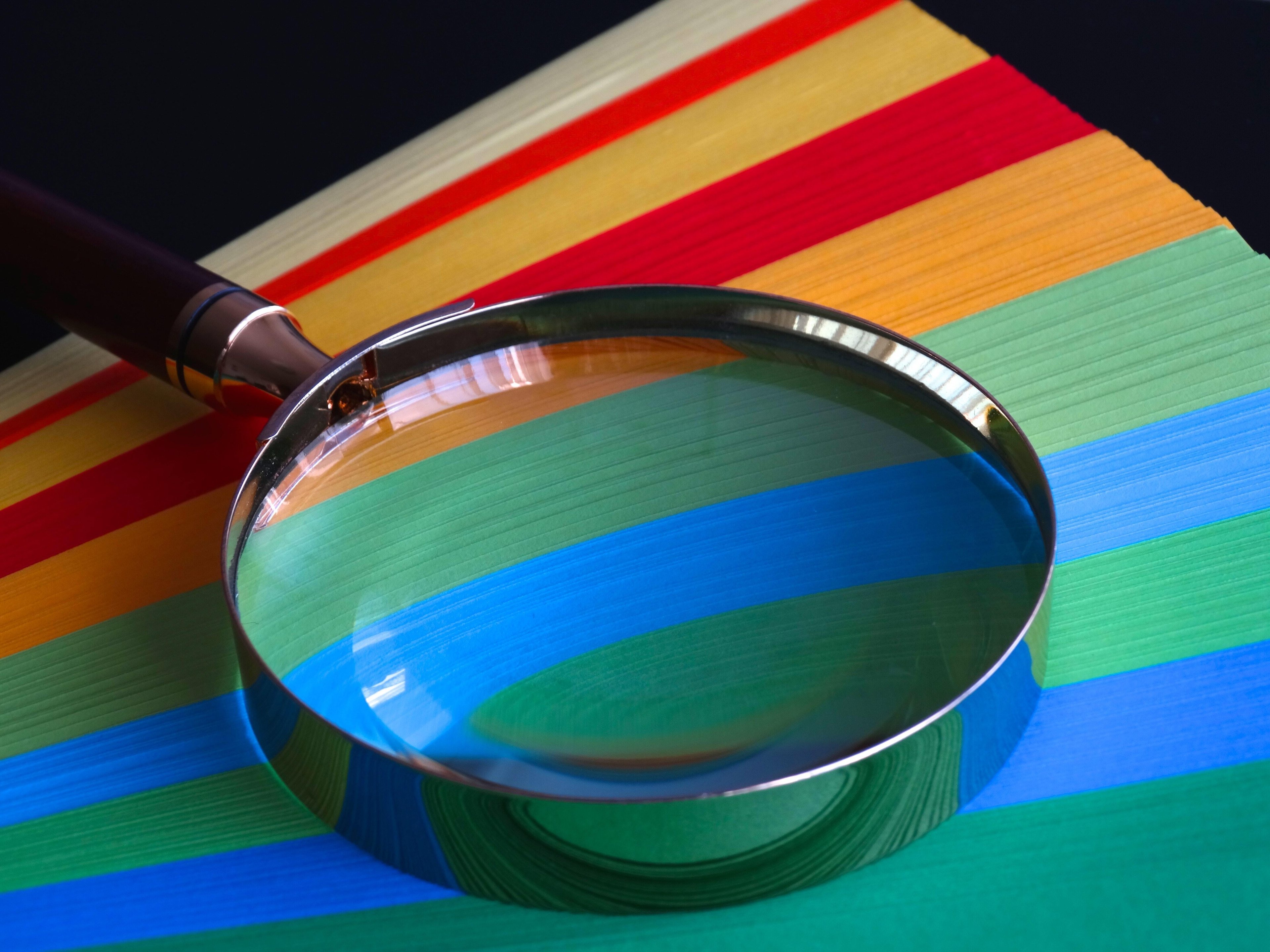 Magnifying glass on colourful paper